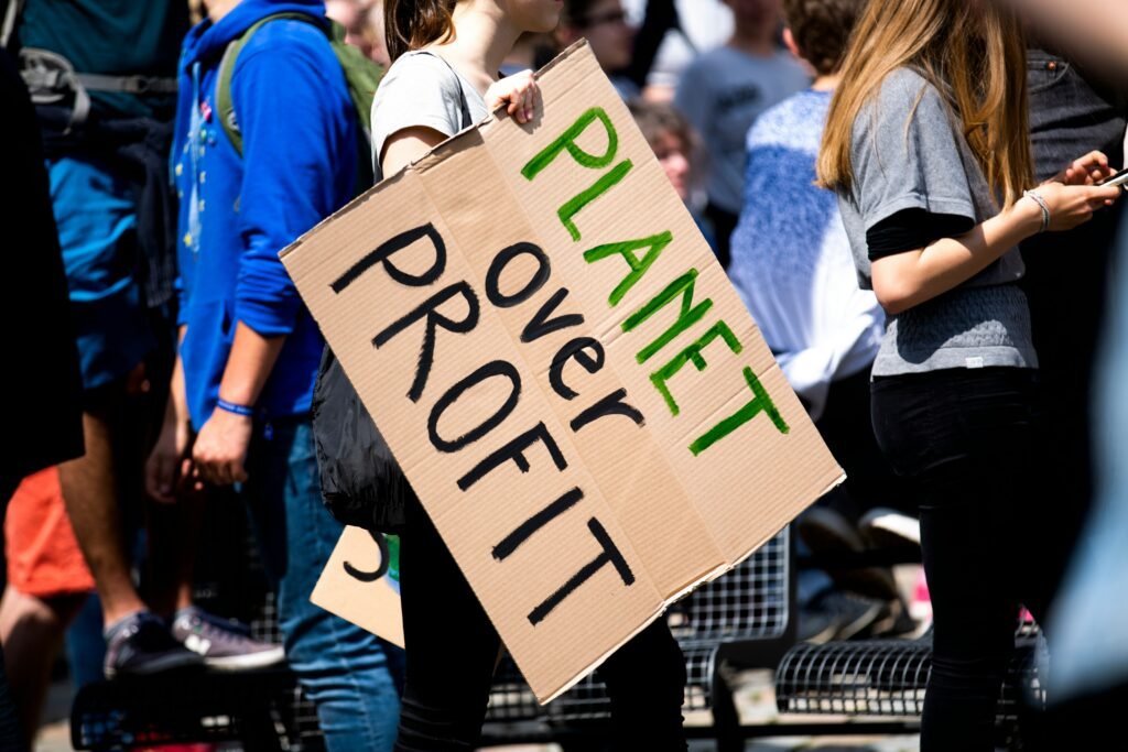 "planet over profit" written on placard and held in a mob to highlight climate urgency