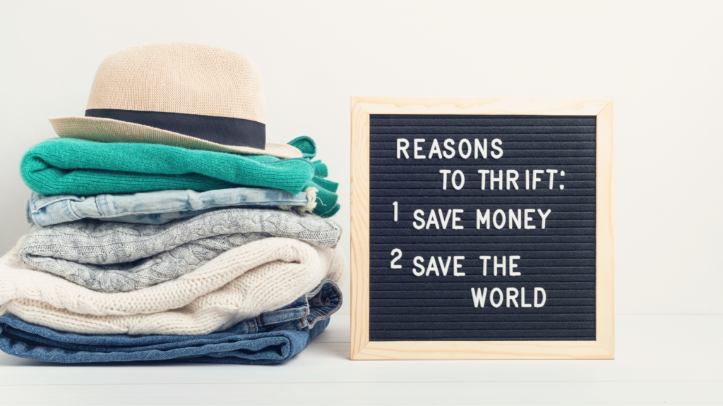 A stack of neatly folded clothing items next to a sign that reads 'REASONS TO THRIFT: 1. SAVE MONEY 2. SAVE THE WORLD.