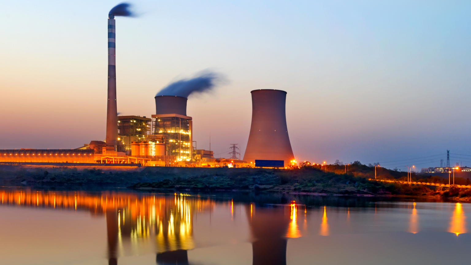 concrete cooling tower controlling thermal pollution alongside a river body